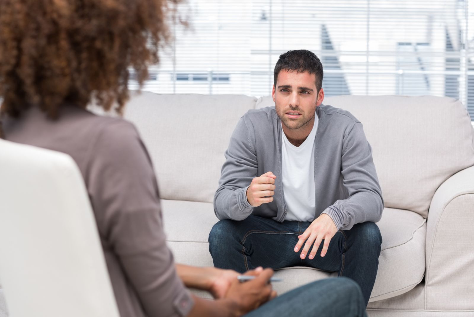A man gestures as he speaks to a therapist